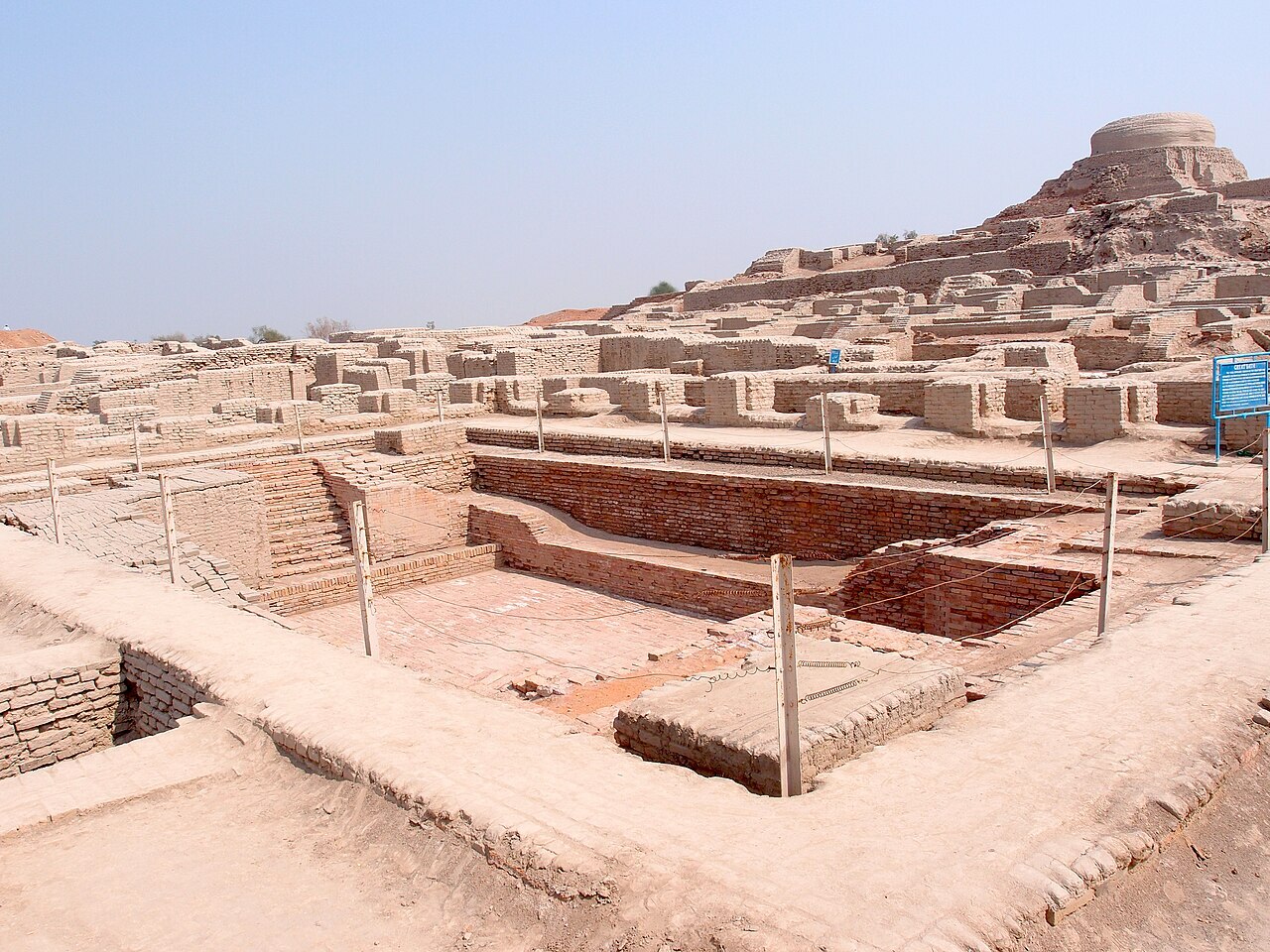 Fouilles de Mohenjo-daro avec le Grand Bassin en arrière plan CC BY-SA Saqib Qayyum, 2014 via Wikimedia Commons